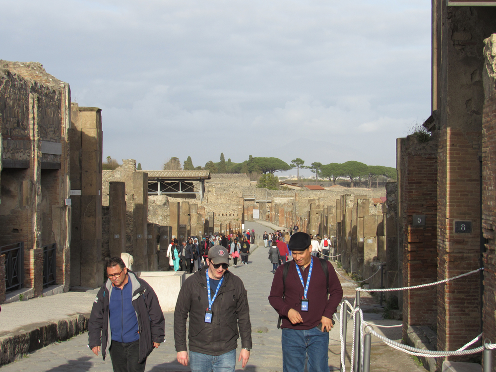 Travellers walking through Pompeii ruins 